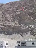 El cartel indicando la posición del nivel del mar, por encima de una zona turística, se encuentra unos dos tercios arriba de la pared de la montaña
