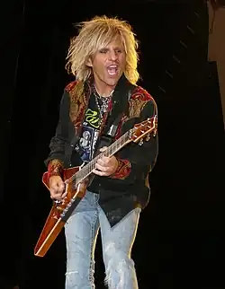 C.C. DeVille Guitarra solista, coros (1985-1991, 1996-presente).