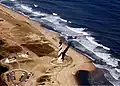 Vista aérea del faro en 1999, antes de su mudanza; la costa del océano se encuentra a escasos 60&nbsp;m de distancia.