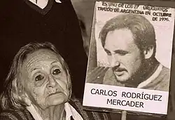 Una mujer con un cartel con la foto de Carlos Rodríguez Mercader