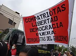 Cartel durante unas protestas contra el gobierno de Pedro Castillo el 28 de julio de 2022. El cartel dice: "Compatriotas, libertad democracia. Fuera: Terroristas del Gobierno".