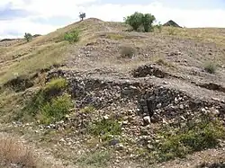 La muralla de la parte inferior del castro, donde se encontró una gran cantidad de puntas de flecha y de proyectiles metálicos pesados, de donde se deduce que esta fue la zona por donde se acometió el ataque más virulento a la muralla. Las hiladas detrás del derrumbe que están ordenadas, son las que delimitan el grosor de la muralla, alcanzando esta en torno a los 5&nbsp;m de ancho