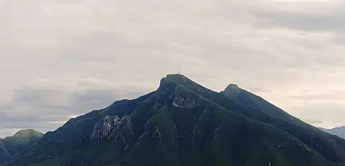 Vista panorámica del Cerro de la Silla con vegetación y cielo nublado.