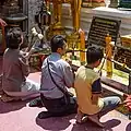 Familia rezando en el templo budista Wat Phra That Doi Suthep (Tailandia).