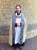Sacerdote anglicano con ornamentos (eucarísticos) catedralicios: sotana negra, sobrepelliz, estola y capa pluvial.