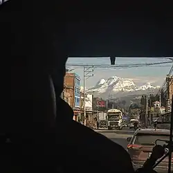 Vista de uno de los nevados que hace parte de la cordillera blanca en Huaraz - Perú. El nevado se observa a través de la ventana del conductor de un transporte público. En la imagen puede observarse la silueta del conductor.