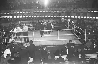 Un ring de boxeo levantado sobre la pista de circo. El combate está pausado por el árbitro.