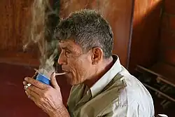 Curandero soplando el extracto de purga