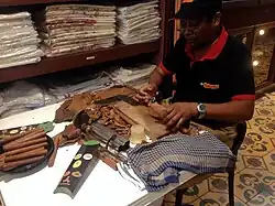 The "torcedor" is considered an artisan. Press and cut the wrapper with a guillotine, roll it up and finish the cigar.