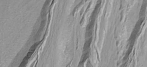 Primer plano de barrancos que muestran formas aerodinámicas en canales, como lo ve HiRISE en el programa HiWish Nota: esta es una ampliación de una imagen anterior..