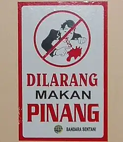 Cartel en Indonesia; la leyenda dice, "Se prohíbe el consumo de betel"