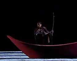 Una mujer con vestuario canta ópera en un escenario.