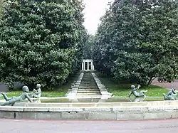 Fuente redondeada con angelotes desnudos en piedra en torno a ella