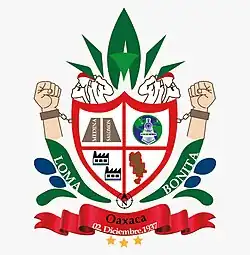 MONOGRAFÍA DEL ESCUDO DE ARMAS DE LOMA BONITA, OAX. Como parte principal del escudo se encuentra el blasón (escudo) en esmalte de gules, con incorporación en la parte superior de dos curvas convexas unidas al centro que hacen referencia a las llanuras formadas por los lomeríos de nuestro municipio; pasando a la parte inferior se ve que los laterales del blasón culminan en punta para enfatizar su base. En su interior se encuentran cuatro planos, los cuales cargan elementos que nos hablan de los inicios de la Loma vieja como fue llamada por la primera congregación de personas. En el primer cuadrante posicionado lado diestro superior se muestran dos mojoneras que portan el apellido de los dos hacendarios que donaron parte de sus terrenos para asentarse, siendo el Sr. Probo Medina el primero en donar tierras para la estación del tren que llevaría su apellido. En el cuadrante siniestro superior encontramos la imagen de un tren saliendo de un globo terráqueo que simboliza el medio de transporte de aquella época que permitió que una colonia de norteamericanos llegará hasta estas tierras y trajera consigo el cultivo de la piña que nos permitió llegar hacer la “Capital Mundial de la Piña”. En el tercer cuadrante ubicado en el siniestro inferior se ejemplifica a las primeras fábricas en las que se realizaba el proceso previo para transportar la piña, las cuales fueron ricas fuente de empleo gracias a lo cual la economía local tuvo un gran impulso. En el cuarto cuadrante, del siniestro inferior, se ubica el contorno territorial que ocupa el municipio. Como timbre encontramos a dos poniteros que simbolizan la fuerza física de los hombre que cosechan nuestra fruta reina, y que en este escudo soporta una figura estilizada que denota la corona de la piña. Como soporte se muestran tres elementos: el primero en esmalte sinople o verde que hace referencia a la planta que es de donde surge la piña, sobre la silueta de las hojas encontramos el nombre que actualmente ostentamos como municipio “Loma Bonita”, el segundo elemento en esmalte azur o azul, son gotas de agua, vital liquido que posee en abundancia la región del Papalopan a la cual pertenecemos. Por encima de la mata encontramos dos manos empuñadas con grilletes en las muñecas y cadenas rotas que anuncian la libertad e independencia como municipio. Por último, a los pies del escudo encontramos un componente conocido como norte en el ámbito geográfico, elemento que hace referencia a la ubicación de nuestro municipio en el estado. Un lienzo que enmarca el estado al que orgullosamente pertenecemos y la fecha en que este nos permitió emanciparnos. Debajo del lienzo tres estrellas en esmalte color oro haciendo referencia al distrito 3, al cual pertenecemos. Es importante destacar que a 82 años de ser municipio libre, Loma Bonita no contaba con este símbolo representativo, el cual es fundamental para cimentar la identidad sociocultural de cualquier pueblo, por lo cual es importante resaltar la iniciativa del ciudadano Raymundo Rivera Hernández, y el respaldo de sus compañeros ediles, para que a partir de este día histórico tengamos nuestro escudo de armas municipal. El cual es producto de la asesoría crónico-literaria del ciudadano Gustavo Cházaro Reyes, del diseño técnico creativo de la Ingeniero Iris Upalia Juárez, y que contó con la corrección de estilo del Ingeniero Gonzalo Contreras Juárez; felicitaciones para ellos.