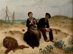 Pareja de pescadores sentados en una playa