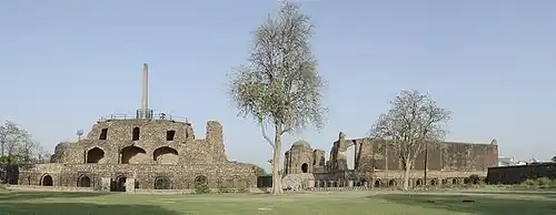 Palacio de Feroz Shah Kotla, tapado por el pilar Delhi-Topra de Ashoka (izqda.) y la mezquita Jamia (dcha.)