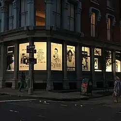 9 posters in windows with childhood photographs and text reclaiming anti-queer slurs