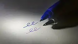 Imagen de puntas de escritura de un bolígrafo de gel y un bolígrafo sobre una hoja de papel junto a las líneas creadas por cada bolígrafo.