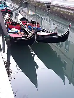 Góndolas de color negro en un canal veneciano