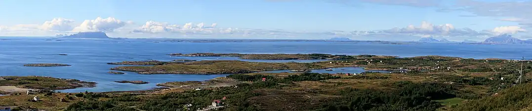 Vista del strandflate en Helgeland desde la montaña Dønnesfjellet en Dønna. Se pueden observar varios rauks, desde la izquierda: Træna, Lovunda, Selvær, Nesøya, Hestmona, Rødøyløva y Lurøyfjellet, todos hitos de la costa noruega.