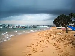 Playa de Hikkaduwa con la visión del coral y los barcos de pesca en el fondo