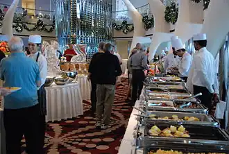 Línea de buffet caliente con personal a bordo del crucero Celebrity Equinox