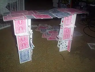 Un castillo de naipes con un puente entre sus dos pilares.