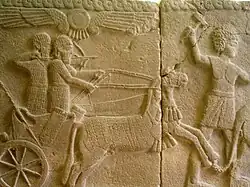 Carro de guerra con arquero y auriga y guerrero avanzando delante del carro.