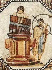 Mosaico del hydraulis, un órgano hidráulico, el primer instrumento de teclado en la historia, precursor de los instrumentos de pulsación. Inventado en el siglo III a. C. por Ctesibio de Alejandría.