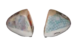 Side view of two iMacs; one has a blue coloring with lighter spots, while the other has multicolored flowers screened on its surface.