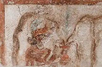 La diosa Lama que esparce agua de un jarrón redondo.