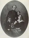 A black-and-white photograph of a mother and father posed with their their son and two daughters