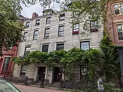 Un par de casas adosadas de granito de imagen especular con fachadas planas en su mayoría sin adornos