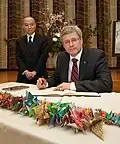El primer ministro Stephen Harper firmando un libro de condolencias por las víctimas del terremoto y tsunami de Tōhoku de 2011 el 23 de marzo de 2011.