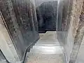 Escaleras tras el elevador hacia el sótano.