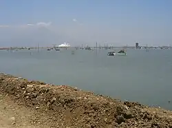 Lago creado por lodo con flujo de lodo humeante de fondo.