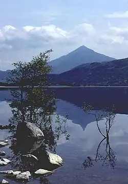 Una montaña simétrica se refleja en las aguas de un lago.