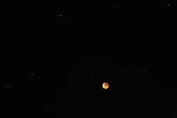 Un ángulo más amplio muestra estrellas alrededor de la luna.