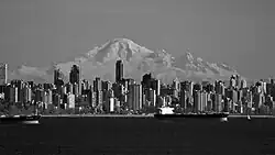 Imagen en blanco y negro del centro de la ciudad de Vancouver, una montaña vista en el fondo.