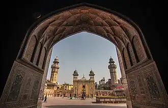 Una vista de la mezquita a través de un arco de acceso a la plaza Wazir Khan Chowk