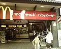 Antigua fachada de McDonald's escrita en katakana: マクドナルド ハンバーガー (Makudonarudo Hanbāgā, "Hamburguesas McDonald's").