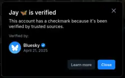 Modal que aparece si haces clic en un check redondo, Dice en inglés: "Jay está verificada. Esta cuenta tiene una marca de verificación porque ha sido verificada por fuentes de confianza. Verificado por" y la imagen del perfil de la cuenta oficial de bluesky