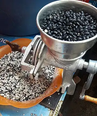 Otra forma de quebrar el frijol, con molinillo.