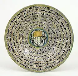 Plato con el emblema de la familia Bonciani con decoración de hojas rizadas. Tipología «italo-morisca». Montelupo, último cuarto del siglo XV.[60]​