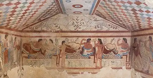 Frescos etruscos de la «tumba de los leopardos» (Tarquinia), donde se representa un simposion, costumbre social de clara influencia griega, representado aquí con el colorido y la concepción festiva propios de la pintura etrusca. Los etruscos desarrollaron una civilización con características orientalizantes dentro del ámbito itálico, del que fueron la potencia dominante hasta que Roma, la capital latina que estuvo sometida a reyes etruscos (Monarquía romana), se terminó imponiendo en los primeros tiempos de la República (del siglo V a. C. al siglo III a. C.).
