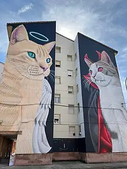 Mural 'Santín y Draculina' de 23 metros en doble fachada de cinco alturas en la calle Río Ebro de Guardo. Obra del artista leonés Manuel García.