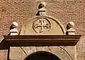 Detalle de la portada conventual. En el tímpano aparece en relieve la cruz de Santo Domingo de Guzmán (el fundador de los dominicos, la orden a la que pertenecía el convento), cuyos brazos rematan en flor de lis.