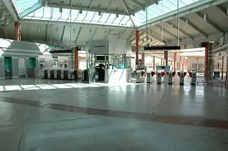 Una entrada vacía de una estación de tren con muchas máquinas expendedoras de billetes situada en una distancia