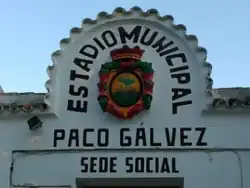 Entrada del Estadio Municipal Paco Gálvez, que conserva el escudo laureado