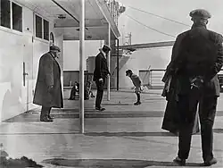 Los pasajeros de primera clase Robert D. Spedden (niño) junto a su padre Frederic (a su izquierda), en la cubierta trasera de paseo A, en la mañana del jueves 11 de abril. Ambos fueron rescatados de la catástrofe.